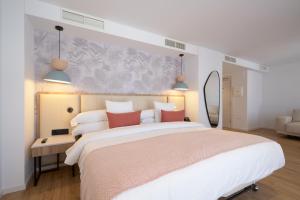 a bedroom with a large white bed with red pillows at Óbal Urban Hotel in Marbella +37 photos