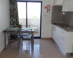 - une cuisine avec une table, des chaises et un évier dans l'établissement Great value 5 mins to Praia de Rocha beach, à Portimão