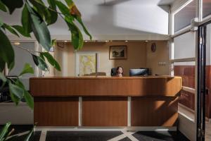 a woman sitting at a reception desk in an office at Boarding House Lucija in Kostrena
