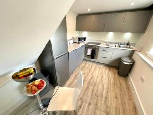 una pequeña cocina con un bol de fruta en una mesa en New Executive Apartment Perfect for Contractors & Pilots en Bishops Stortford