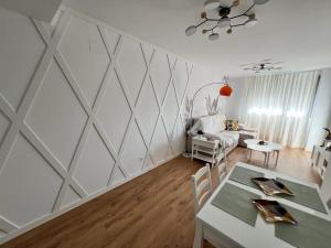 una sala de estar con una pared blanca con un patrón geométrico en Jardines del Porvenir 2 en Puerto Real