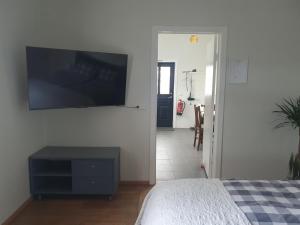 a bedroom with a flat screen tv on the wall at Vorsabær Apartment in Selfoss