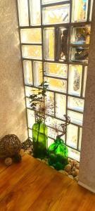 zwei grüne Vasen auf einem Tisch vor einem Fenster in der Unterkunft Ferienwohnung Vintage in Sankt Martin