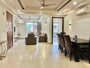 a dining room with a table and chairs and a living room at Bedchambers Serviced Apartments, Ardee City in Gurgaon