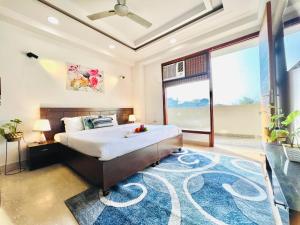 a bedroom with a large bed with a blue rug at Bedchambers Serviced Apartments, Ardee City in Gurgaon