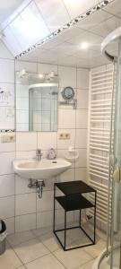 ein Bad mit einem Waschbecken und einem Spiegel in der Unterkunft Ferienwohnung Vintage in Sankt Martin