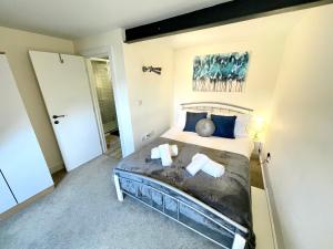 a bedroom with a large bed with blue pillows at New Executive Apartment Perfect for Contractors & Pilots in Bishops Stortford