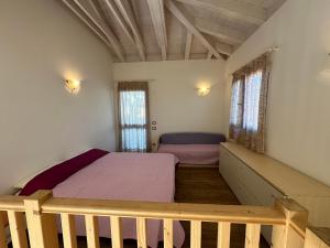カオルレにあるRESIDENCE STEFANIA ATTICI SU 2 LIVELLI - AGENZIA COCALのベッドと2つの窓がある寝室