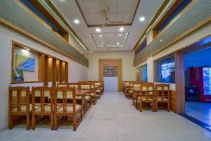 uma sala de conferências com mesas e cadeiras de madeira em Hotel City Crown, Kolhapur 200 Mts from Bus Stand em Colhapur