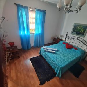- une chambre avec un lit doté de draps bleus et une fenêtre dans l'établissement Mgrahamhouse, à Tacoronte
