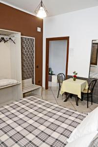 1 dormitorio con 1 cama y 1 mesa con sillas en Villa Nancy Affittacamere, en Cimitile