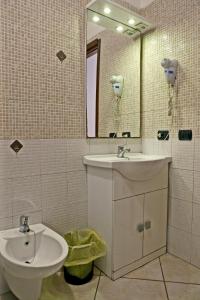 y baño con lavabo, aseo y espejo. en Villa Nancy Affittacamere, en Cimitile