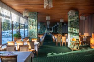 een eetkamer met tafels, stoelen en ramen bij Zespół Tatry - Hotel Tatry i Budynek Turystyczny in Murzasichle