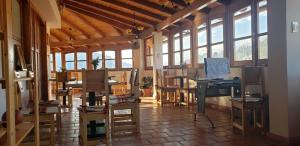 a room with a desk and chairs and windows at Lunandina Huaraz in Huaraz