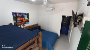 1 dormitorio con 1 cama y una pintura en la pared en Hostal Paraiso Minca, en Minca