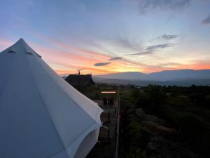 a white tent with a sunset in the background at Iraca Glamp in Santa Sofía