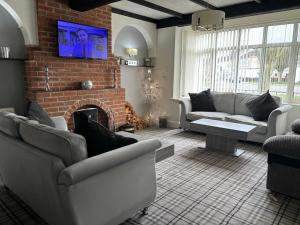 a living room with couches and a brick fireplace at The Saxby Hotel in Skegness