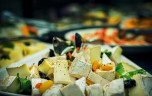 a plate of cheese and vegetables on a table at Hotel Europa Fit H&eacute;v&iacute;z in H&eacute;v&iacute;z