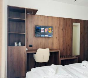 um quarto com uma cama, uma secretária e uma cadeira em Apartments & rooms Artemus Belveder em Koper