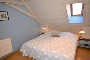 una camera da letto con un grande letto in mansarda di Chambres d'hôtes Chez Caroline a Colmar