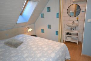 Chambres d'hôtes Chez Caroline في كولمار: غرفة نوم بسرير ومغسلة ومرآة
