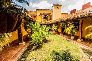 an exterior view of a yellow house with plants at La Casa Amarilla in Mompos