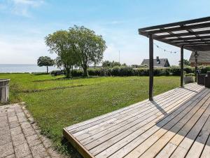 a wooden deck with a view of the ocean at 8 person holiday home in Tranek r in Fæbæk