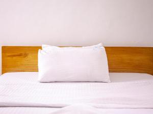 a white pillow sitting on top of a bed at Explorers Hub in Kampala