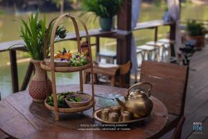 a table with baskets of fruit and a tea kettle at ทับทิมทอง โฮมสเตย์ in Ban Khlong Khut