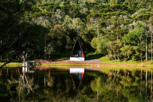 a small cabin on the shore of a lake at Oásis Pousada in Cambará