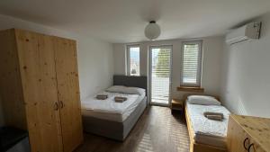 a bedroom with two beds and two windows at Vila Eva Lesce - Bled in Lesce