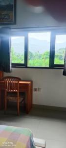 a bedroom with a desk and a chair in front of a window at Lumbung Sari Home Stay in Amed