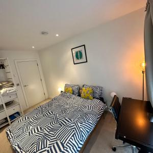 um quarto com uma cama com um edredão preto e branco em Central Room In Shoreditch em Londres