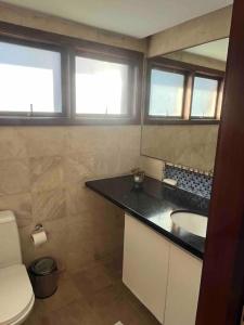 a bathroom with a sink and a toilet at Casa em resort na Taiba in São Gonçalo do Amarante