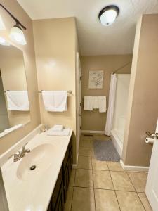 ein Badezimmer mit einem weißen Waschbecken und einer Dusche in der Unterkunft Homey Townhouse Near Lake & Sports Complex in Guntersville