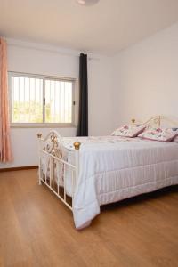 a bedroom with a white bed and a window at Rose de Palmarejo Grande T2 in Praia