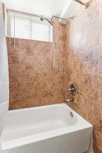 y baño con bañera blanca y ducha. en Charming Hyattsville Home Near DC, en Hyattsville