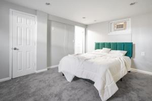 - une chambre avec un grand lit et une tête de lit verte dans l'établissement Charming Hyattsville Home Near DC, à Hyattsville