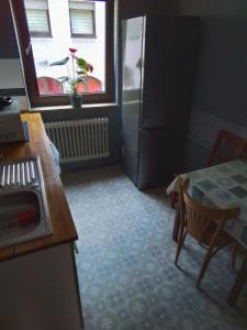 a small kitchen with a table and a refrigerator at MB City Pension in Nuremberg