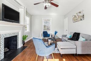 un salon avec une cheminée et une chaise bleue dans l'établissement Charming Hyattsville Home Near DC, à Hyattsville