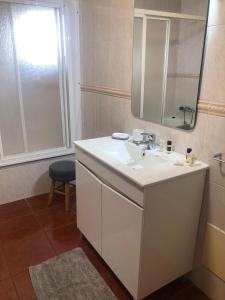 a bathroom with a white sink and a mirror at Casa das Borboletas in Évora