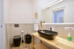 baño con lavabo negro y espejo en B&b Apartment Roma Centre, en Roma
