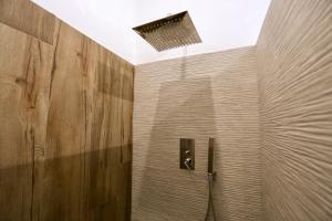 y baño con ducha y pared de madera. en B&b Apartment Roma Centre, en Roma