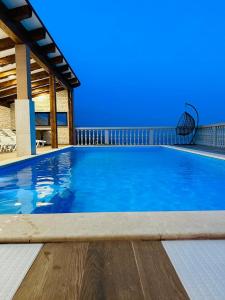 a large blue swimming pool with a chair at Holiday Home Robert 2 with pool in Cesarica