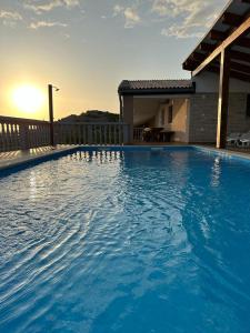 a large blue swimming pool in front of a house at Holiday Home Robert 2 with pool in Cesarica