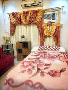ダバオシティにあるAffordable Spacious Bedroom & Bathroom near DVO Airportのベッドルーム1室(ベッド1台付)、窓(カーテン付)