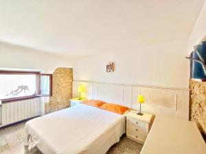1 dormitorio con cama blanca y ventana en Agriturismo Podere Santa Rita, en Montescudaio