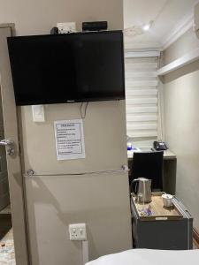uma televisão em cima de um frigorífico num escritório em elim glamour hotel em Elim