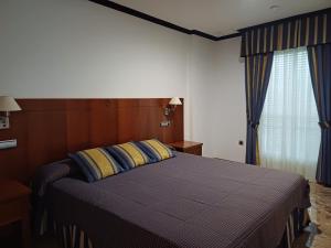 - une chambre avec un lit doté d'oreillers bleus et jaunes dans l'établissement Cazorla LIVE, à Cazorla