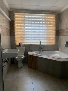 uma casa de banho com uma banheira, um WC e um lavatório. em elim glamour hotel em Elim